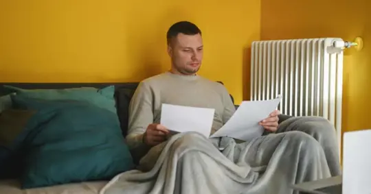 Worried mid adult man holding bills for electricity and gas